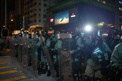 People standing on illuminated street at night