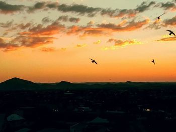 Silhouette of townscape against orange sky