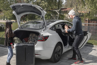 Man putting daughter into car