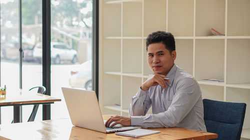 Portrait of man sitting on table