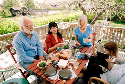 Multi-generational family enjoying food at table in patio
