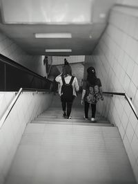 Rear view of women walking in subway