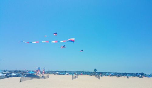 Scenic view of beach against clear blue sky