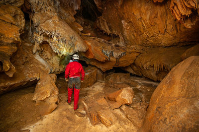 Rear view of man standing on rock formation