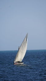 Sailboat in sea against clear sky