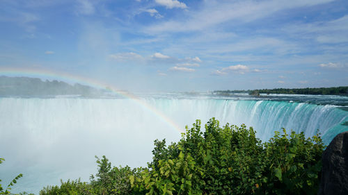 Scenic view of waterfall against sky