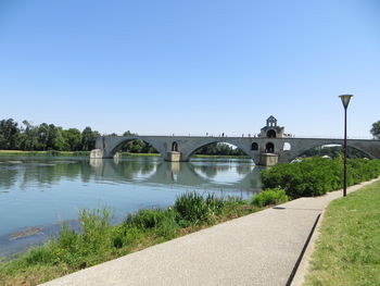 Bridge over river against clear blue sky