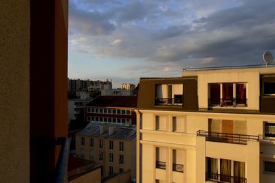 Buildings in city against cloudy sky