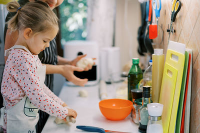 Side view of cute baby girl in kitchen