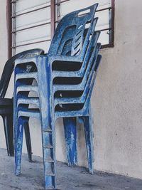 Empty chairs against wall in old house