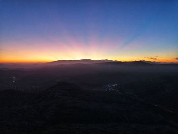 Scenic view of silhouette mountains against sky at sunset