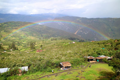 Scenic view of rainbow over mountain against sky