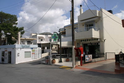 Houses by street in town against sky