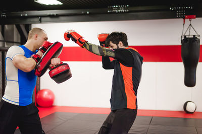 Men practicing in boxing ring