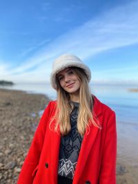 Portrait of young woman standing at beach