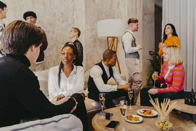 Business colleagues discussing with each other while having food and drinks during event at convention center