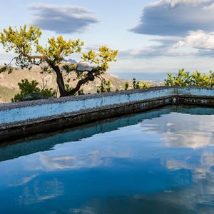 Scenic view of swimming pool by lake against sky