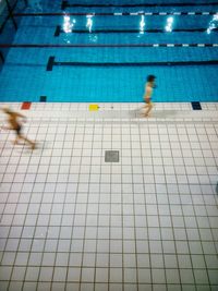 High angle view of shirtless boys running at poolside