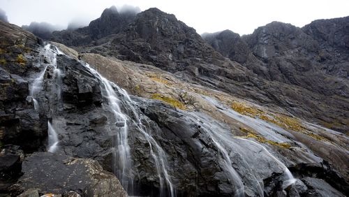 Scenic view of waterfall against sky