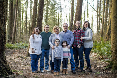 Portrait of happy family of eight in the forest.