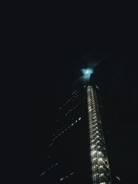 Low angle view of illuminated skyscraper against sky at night