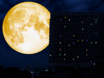 Close-up of illuminated lamp against sky at night