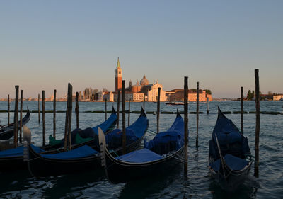 Boats moored in sea against clear sky