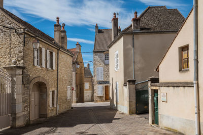 Street amidst buildings in town against sky