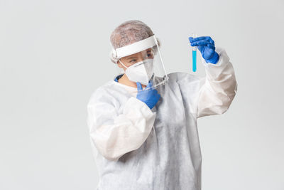 Midsection of man wearing mask against white background