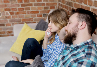 Man and woman watching tv at home