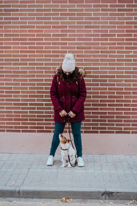 Man with dog against brick wall