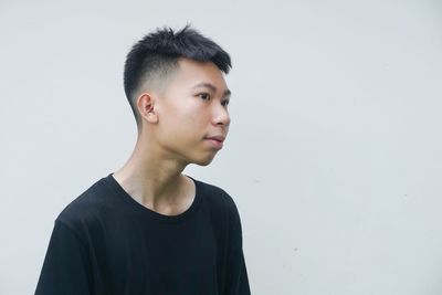 Thoughtful young man looking away against white background