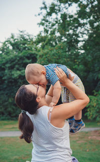 Rear view of mother and son against trees