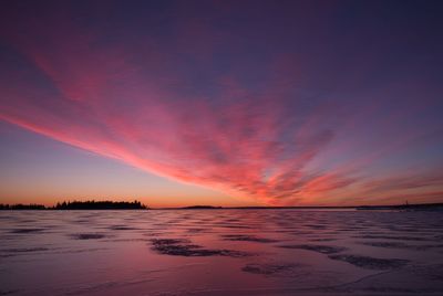 Scenic view of sea against dramatic sky during sunset