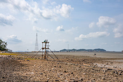 Electricity pylon on field against sky