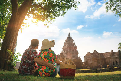 Men sitting in temple against sky