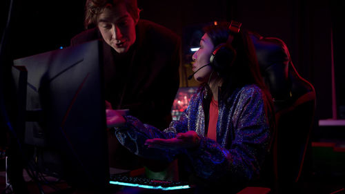 People playing video game in darkroom