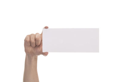 Low angle view of person holding paper against white background