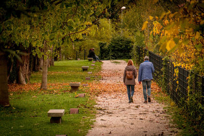 Rear view of couple walking on footpath