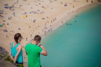 Rear view of friends standing on beach