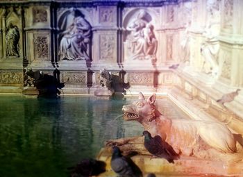 Reflection of man sculpture in water