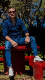 Portrait of young man wearing sunglasses sitting on seat