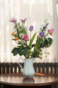 Close-up of white roses in vase on table at home