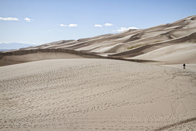 Man walking in great sand dunes national park and preserve against sky