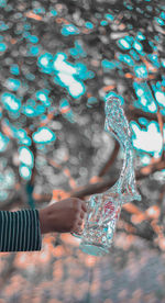 Close-up of woman holding umbrella against blurred background