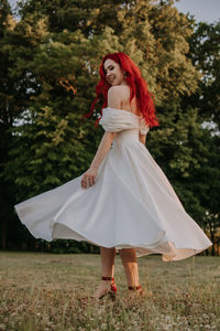 Wedding day. happy bride with redhead whirling and laughing in the park