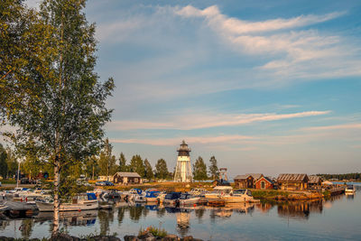 View of trees by river against sky