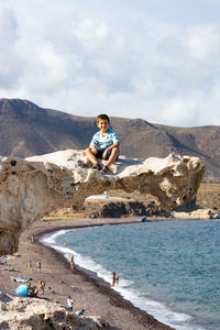 Portrait of a little kid on a rock of playa del arco, almeria, spain