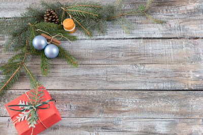 Close-up of christmas present and decorations on wood