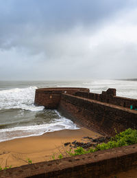 Candolim beach by fort aguada against sky